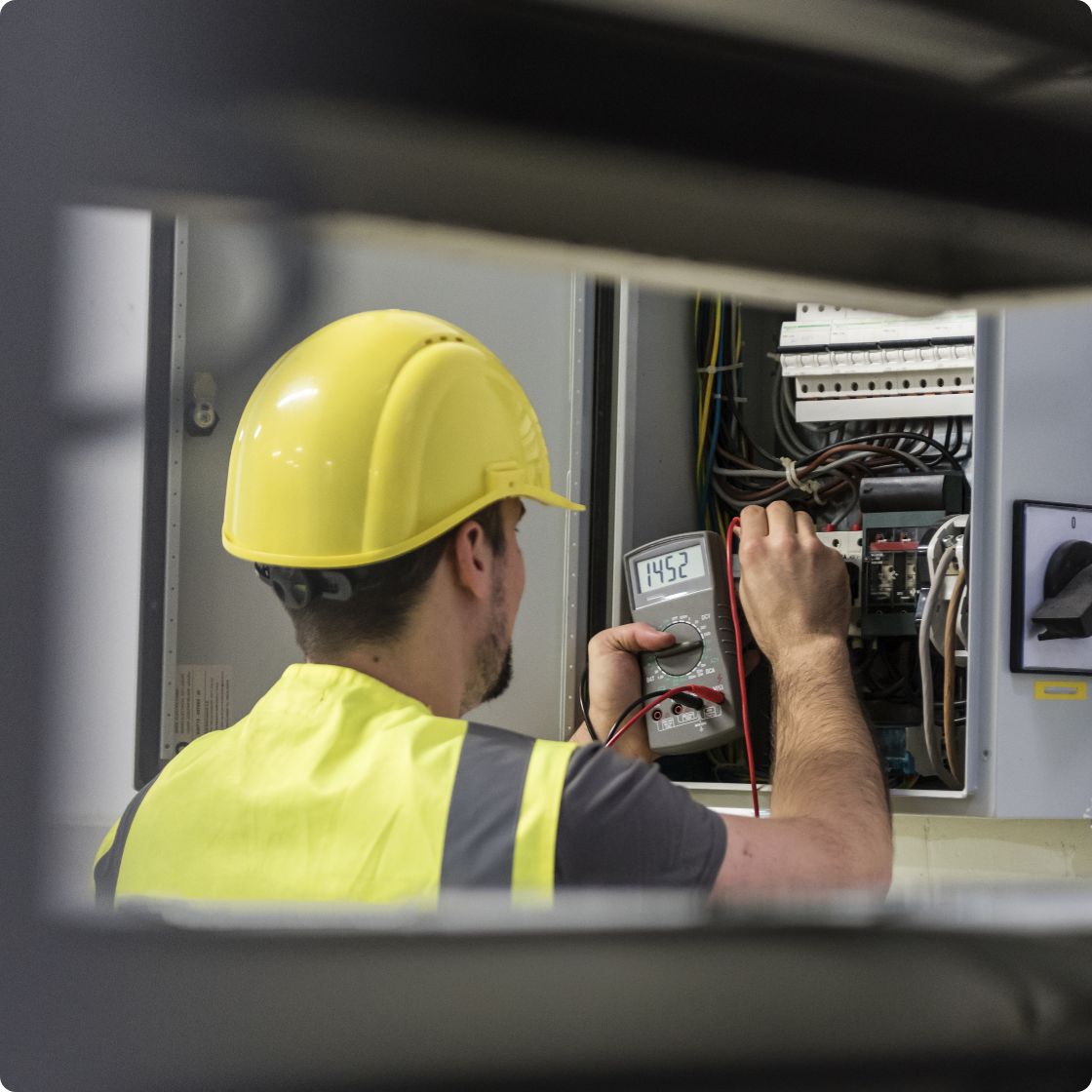 Man is testing electricity installation with multimeter