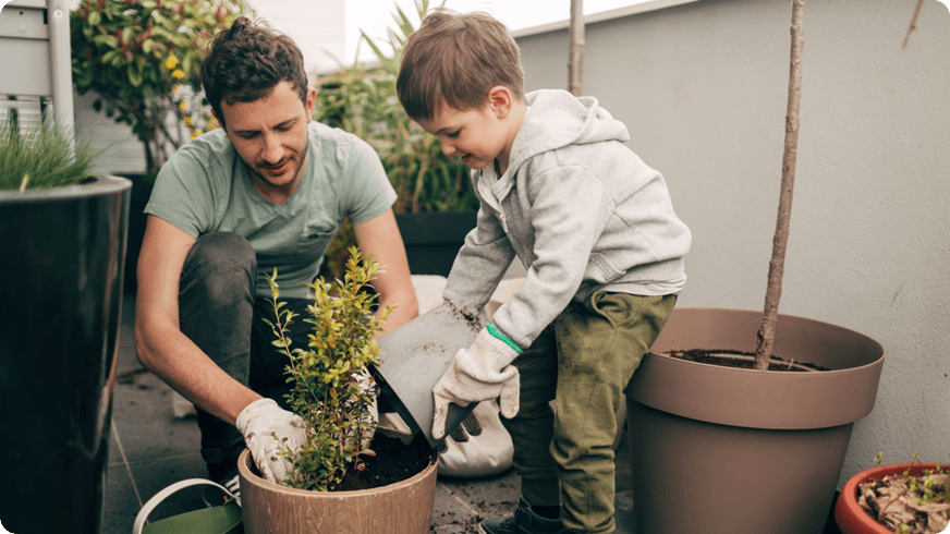 Tėvas ir vaikas sodina vazoninius augalus
