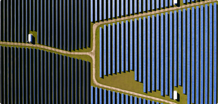 Saulės elektrinių parkas matomas iš paukščio skrydžio, šviečiant saulei.