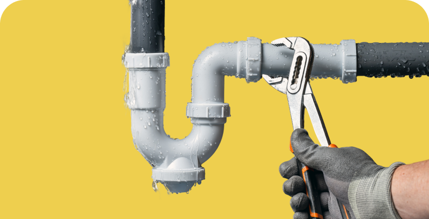 Meistras remontuoja kriauklės vamzdį.