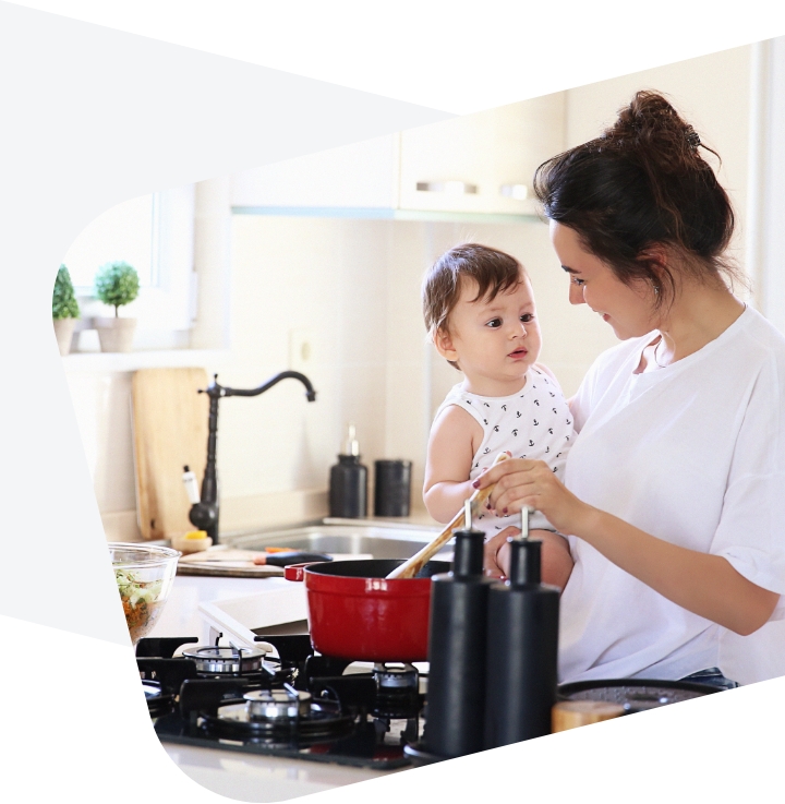Mama gamina maistą su vaiku rankose