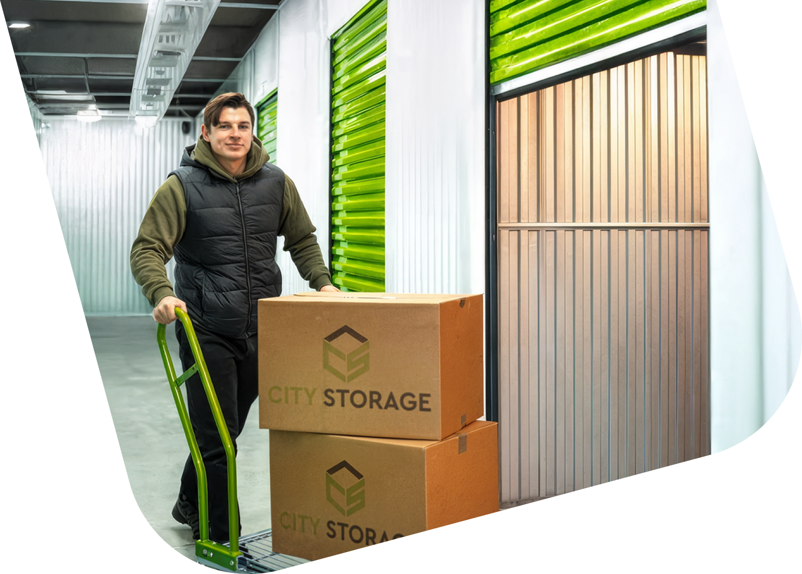 Aurimas Valujavičius su vežimėliu veža dėžes į City Storage sandėliuką.