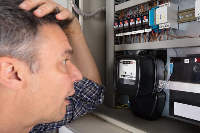 Nustebęs vyras prie elektros skaitliuko