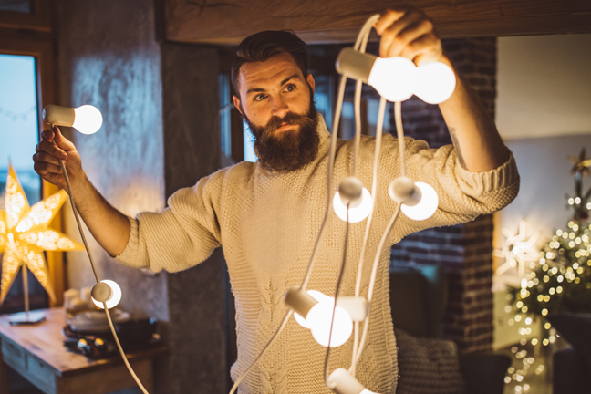 Vyras rankose laiko kalėdinę girliandą