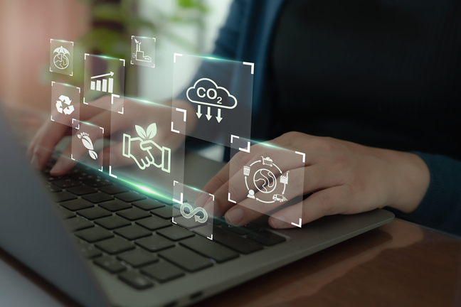Žmogus naudojasi nešiojamu kompiuteriu, o virš kompiuterio ore sklando peršviečiamos ikonėlės, kurios susijusios su klimato kaitos mažinimu.